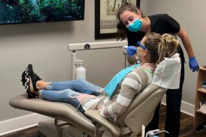 A woman in a dental chair getting her teeth checked.